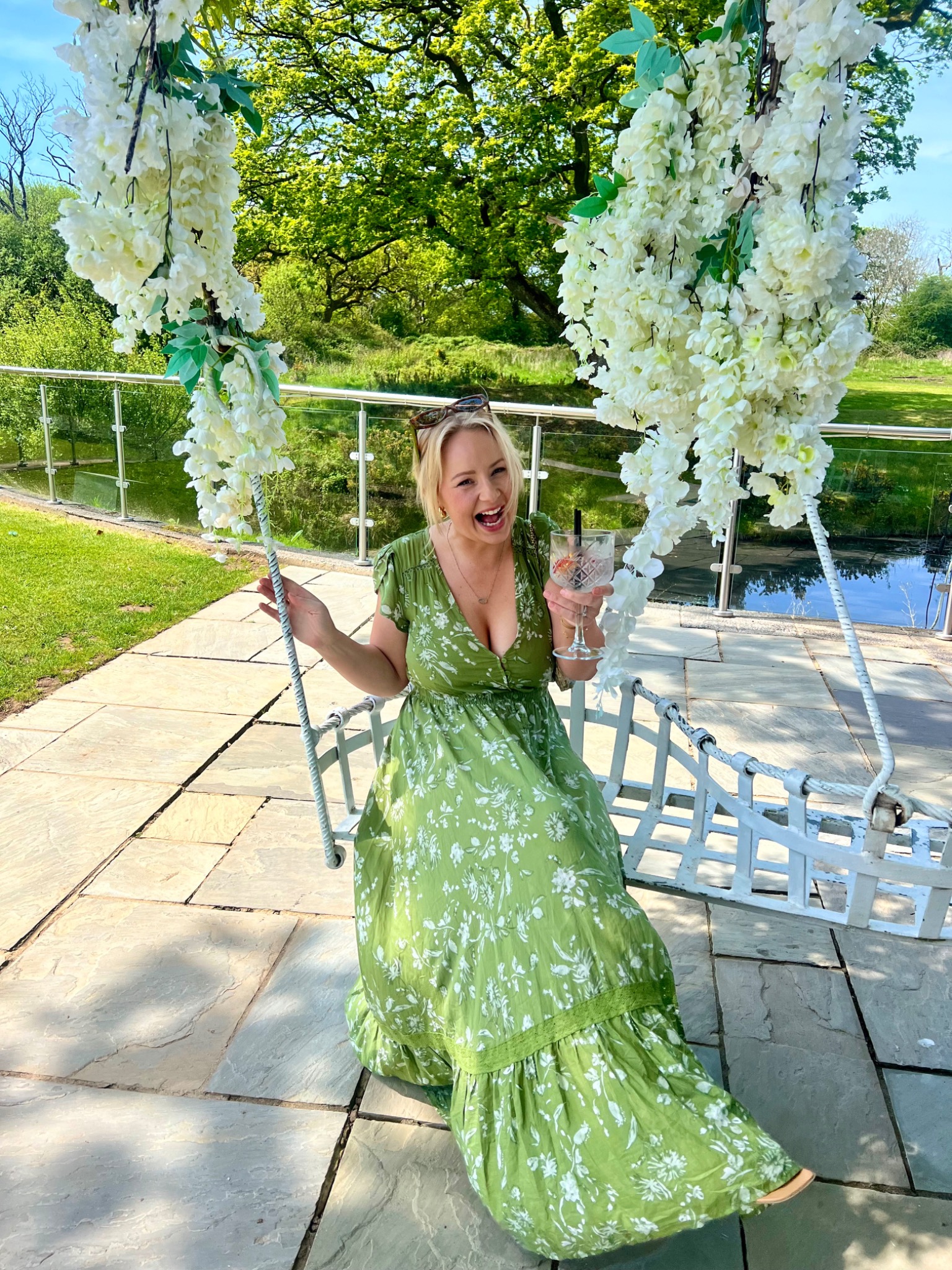 Rebecca smiling on a flower-covered garden swing